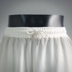 White drawstring shorts with elastic waistband and metal eyelets