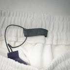 White shorts with drawstring and tag near inner waistband