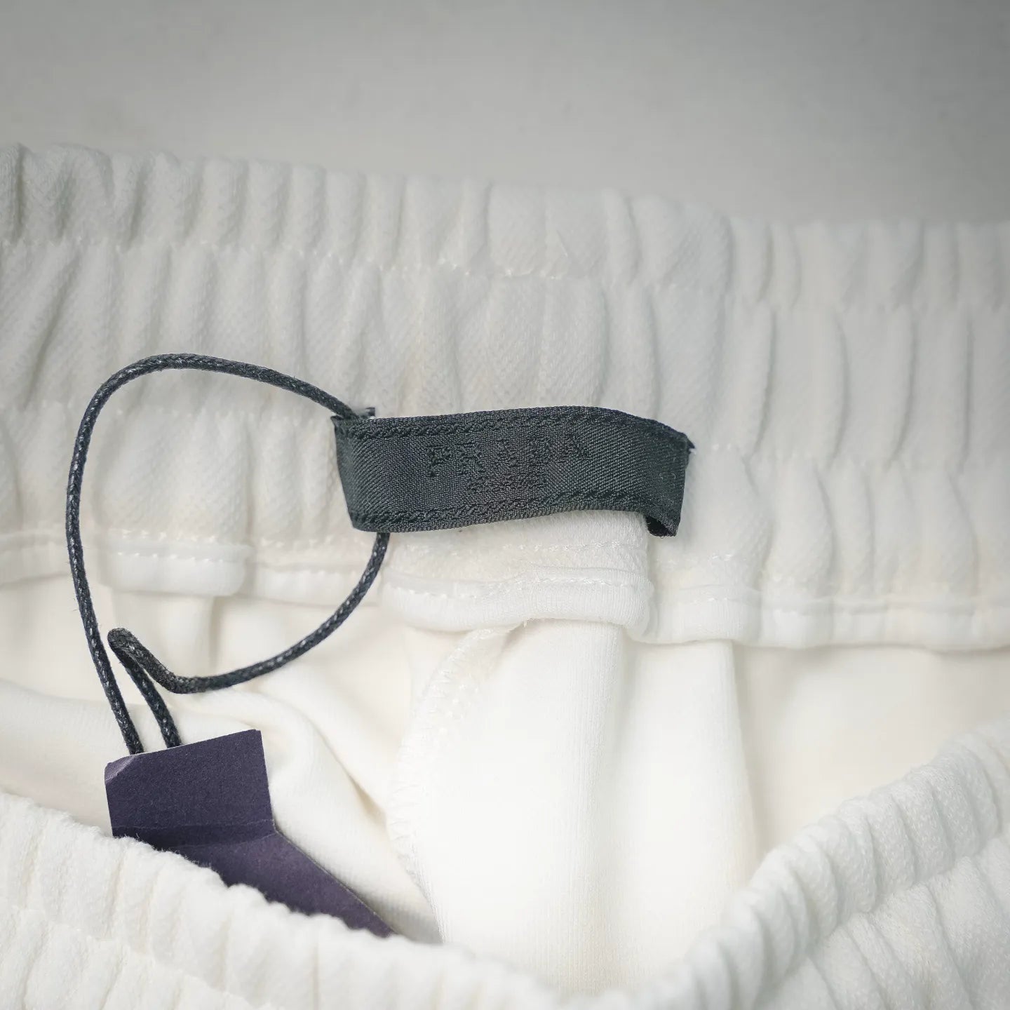 White shorts with drawstring and tag near inner waistband