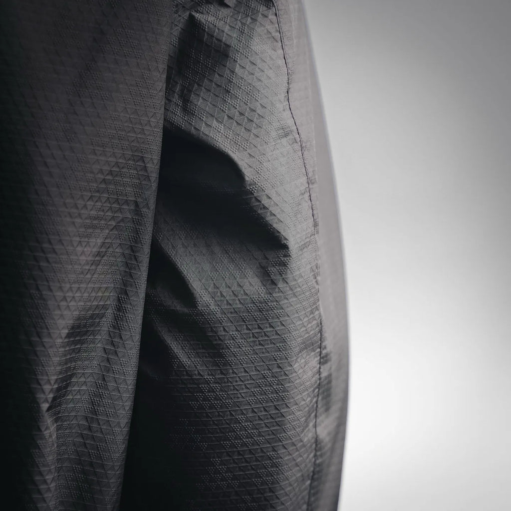 Close-up of black jacket fabric with textured diamond pattern