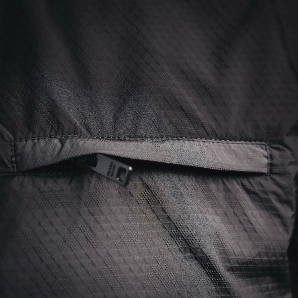 Black jacket waistband with small interior brand tag near hem