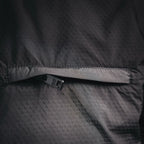 Black jacket waistband with small interior brand tag near hem