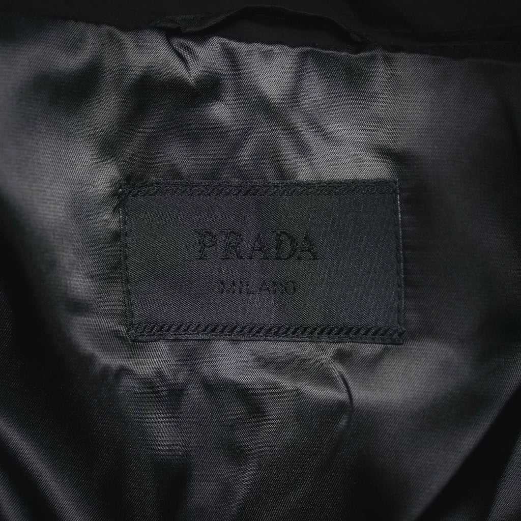 Black fabric care label showing PRADA printed text