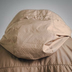 Tan hooded jacket close-up with quilted textured fabric