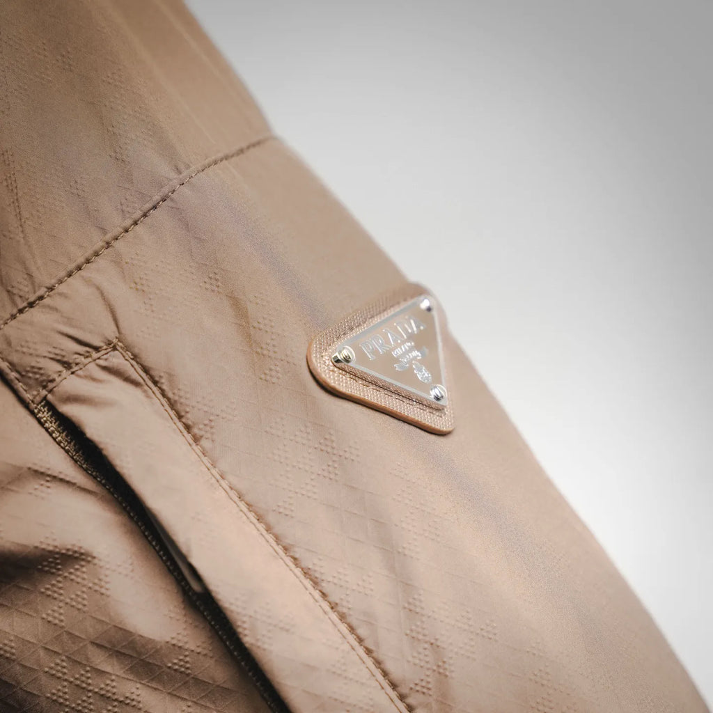 Prada tan jacket sleeve with logo patch near the cuff