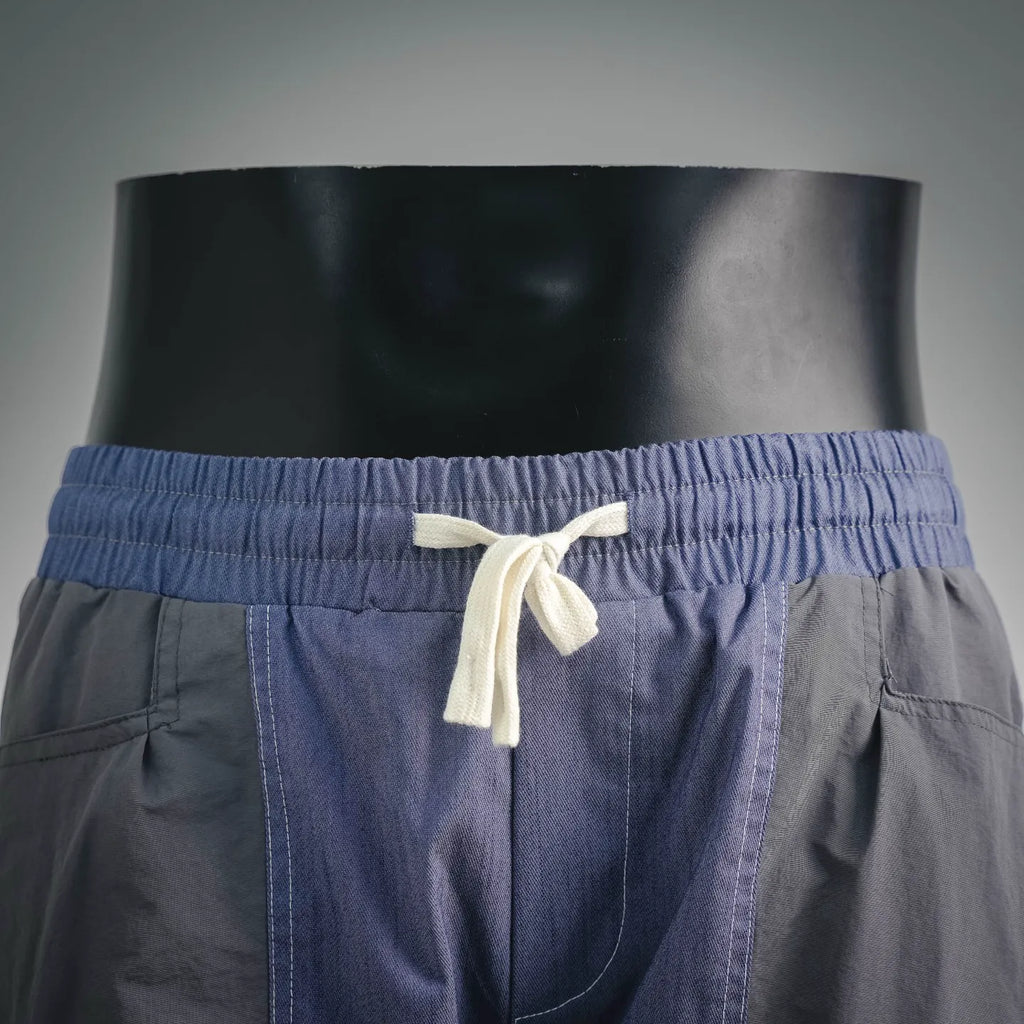 Prada blue shorts with white drawstring tied at elastic waistband