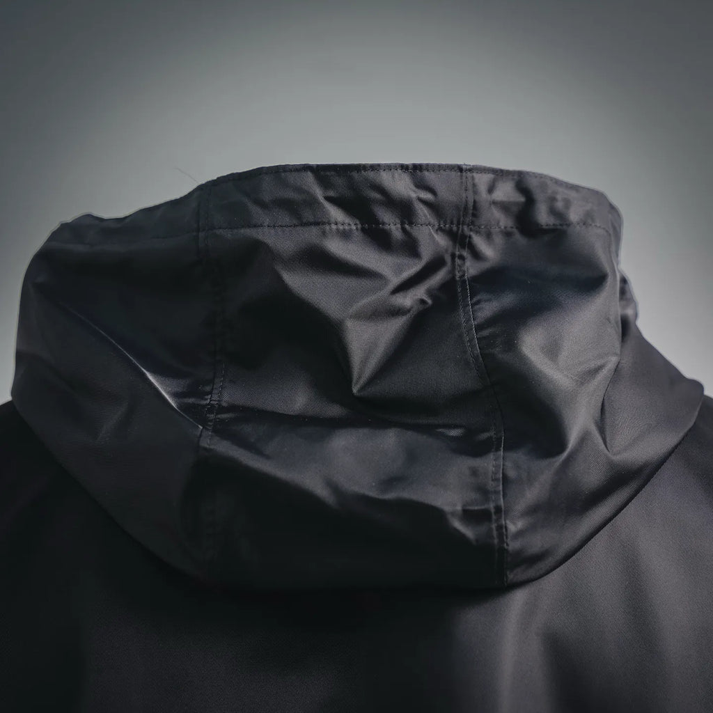 Black hood close-up with draped fabric and stitched seam lines