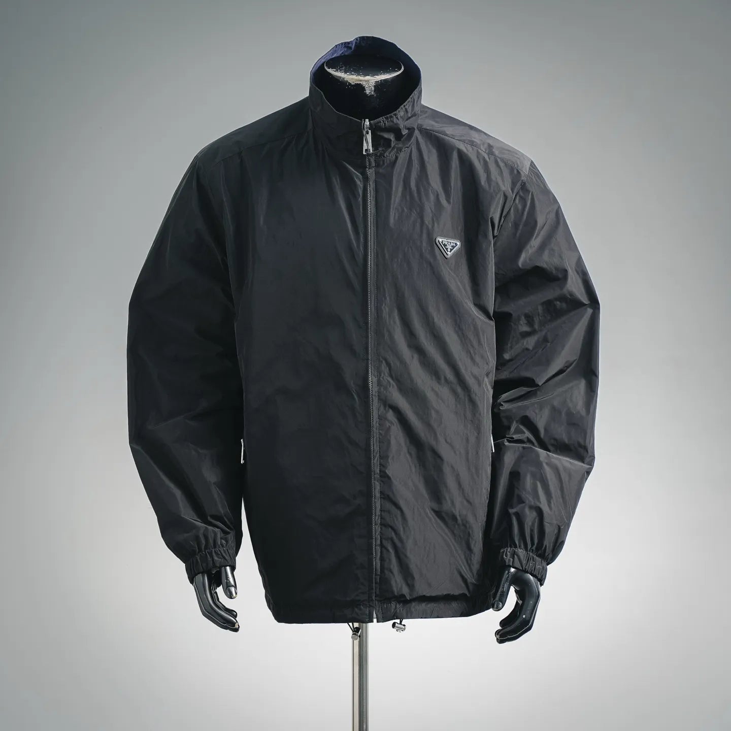 Black zip-up nylon jacket with stand collar and Prada logo patch