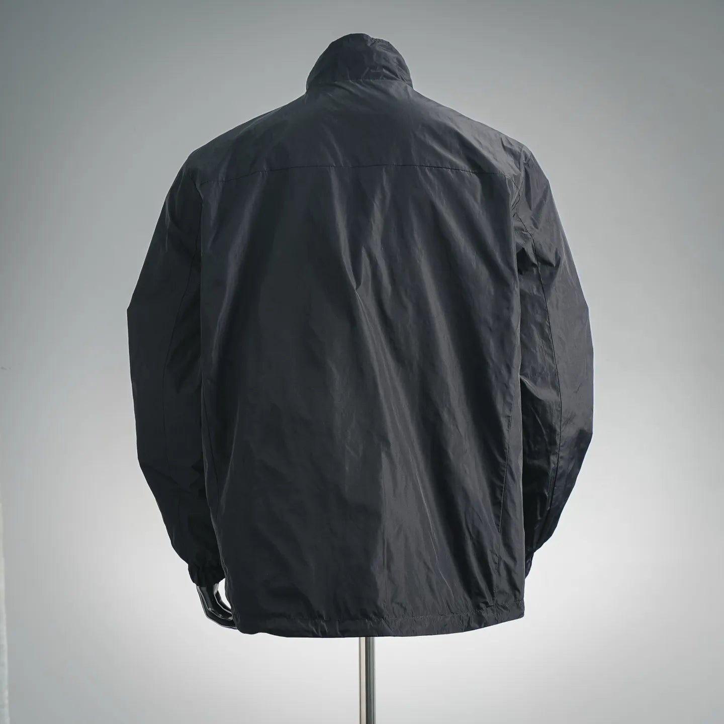 Black zip-up nylon jacket back view with stand collar