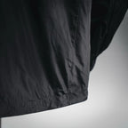 Black nylon jacket hem with elasticized trim and seam detail