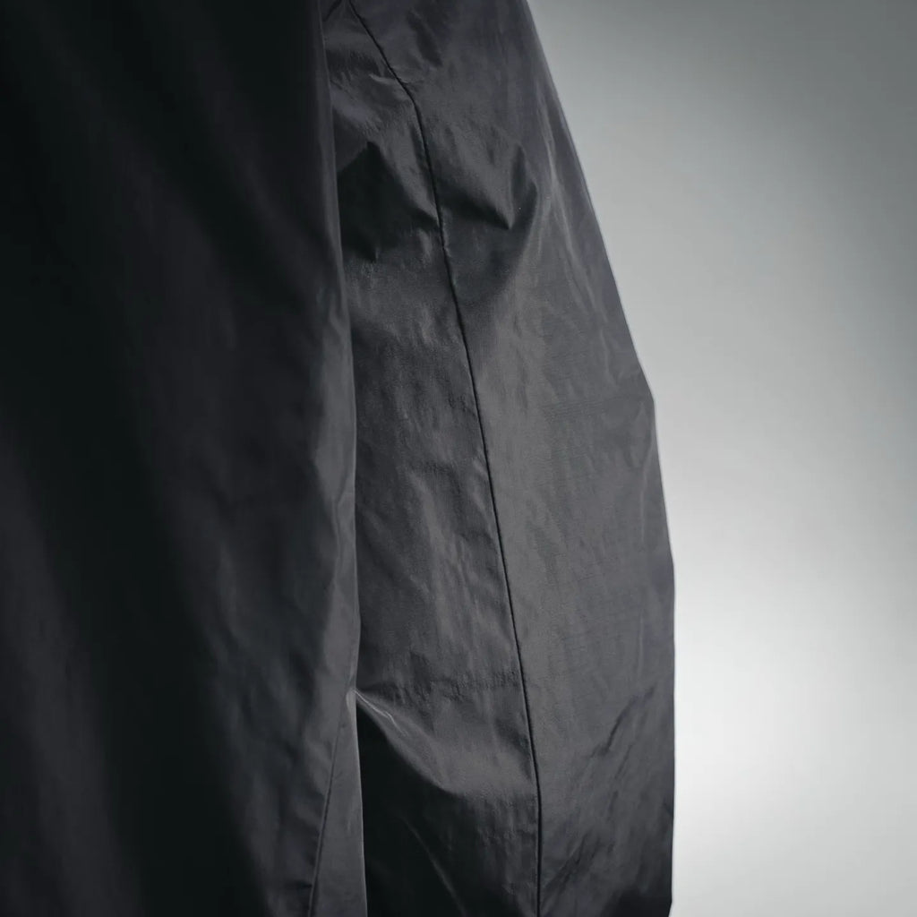 Black nylon jacket side seam with pocket opening