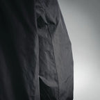 Black nylon jacket side seam with pocket opening
