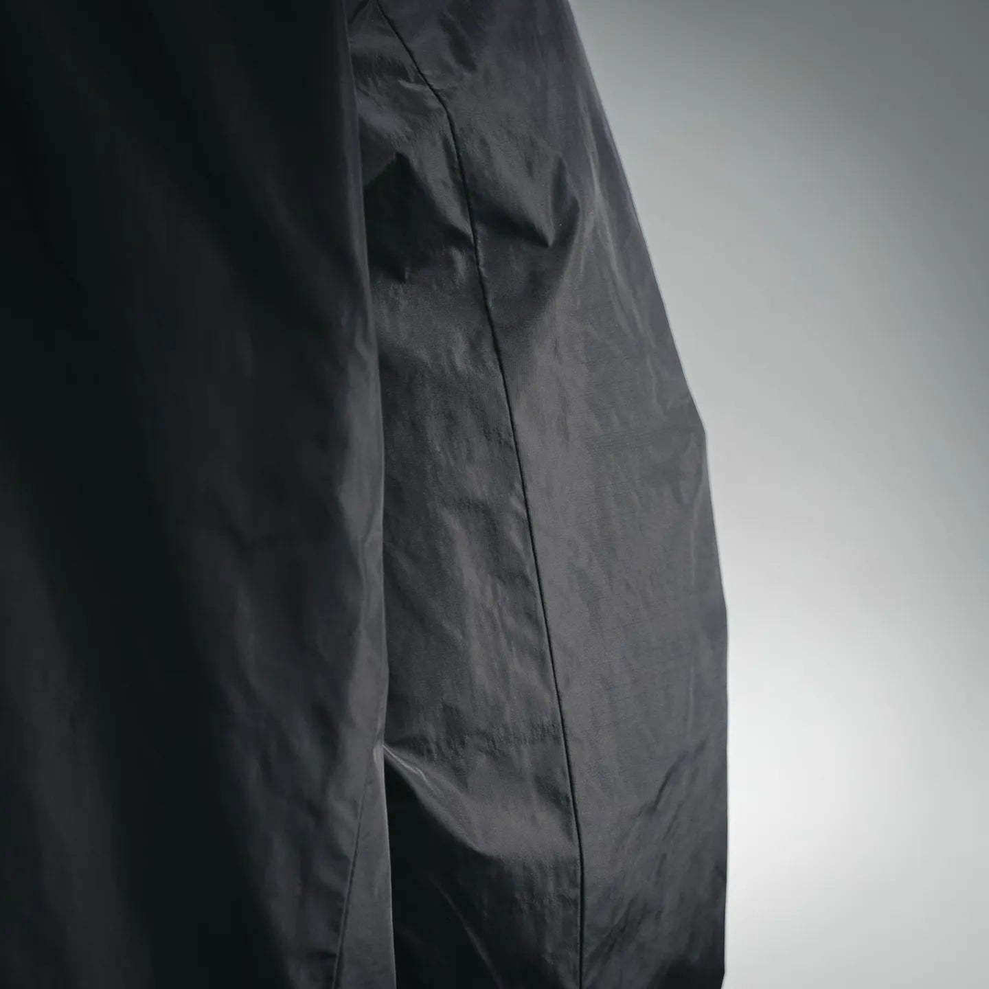 Black nylon jacket side seam with pocket opening