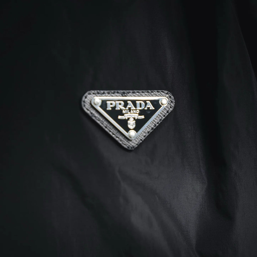 Prada triangular logo patch on black nylon jacket