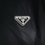 Prada triangular logo patch on black nylon jacket
