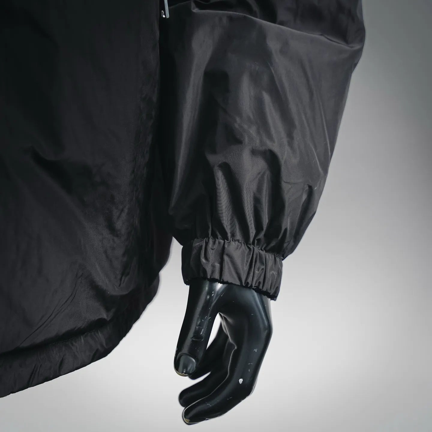 Black nylon jacket sleeve with elastic cuff on mannequin hand