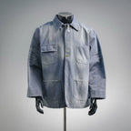 Light blue denim utility jacket with button front and chest patch pockets