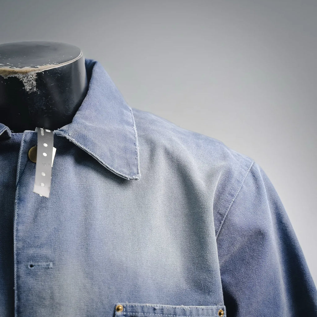 Light blue denim jacket collar with button and flap detail