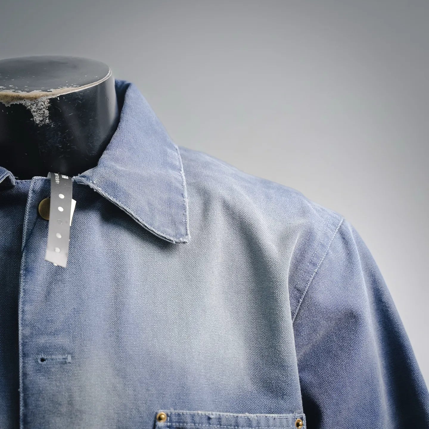 Light blue denim jacket collar with button and flap detail