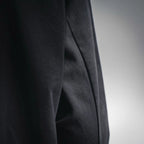 Black jacket sleeve with subtle woven texture, side seam