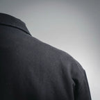 Black jacket shoulder and upper sleeve seam, textured fabric
