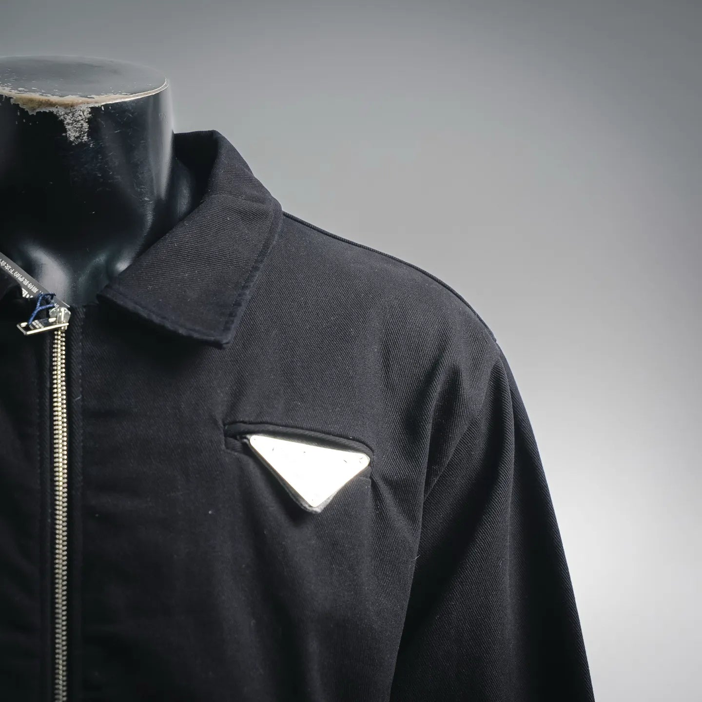Black jacket collar with zipper and triangular chest patch pocket
