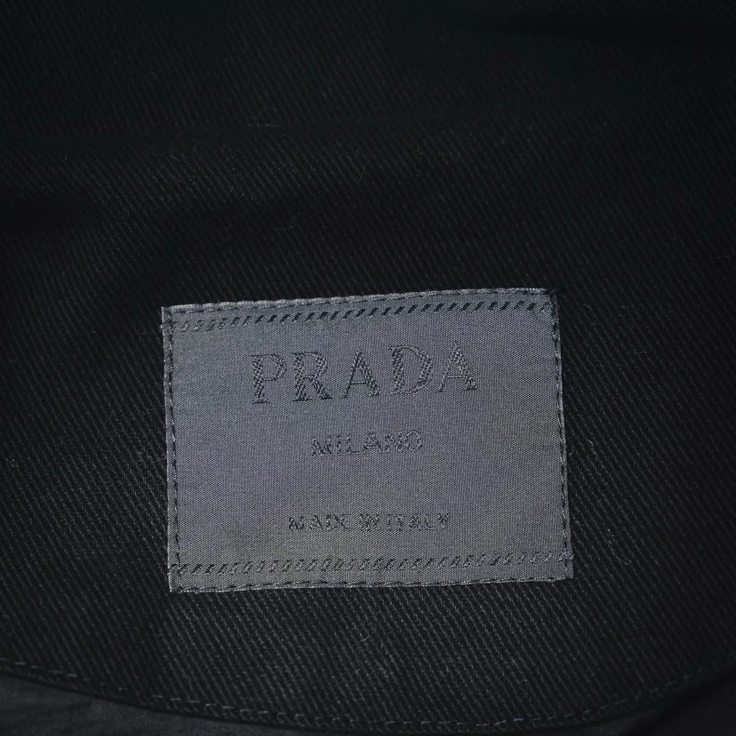 PRADA Milano size label inside black jacket, stitched tag