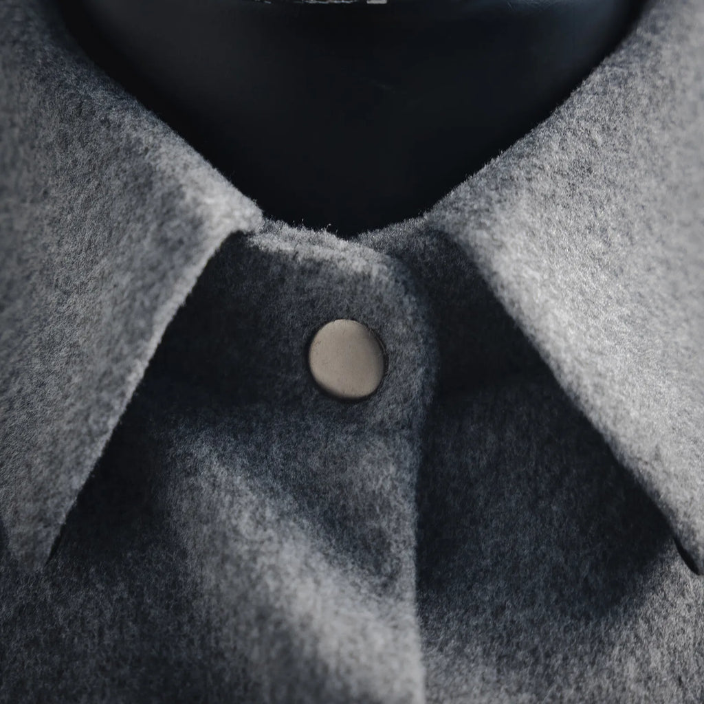 Gray wool jacket neckline with round button and soft wool texture
