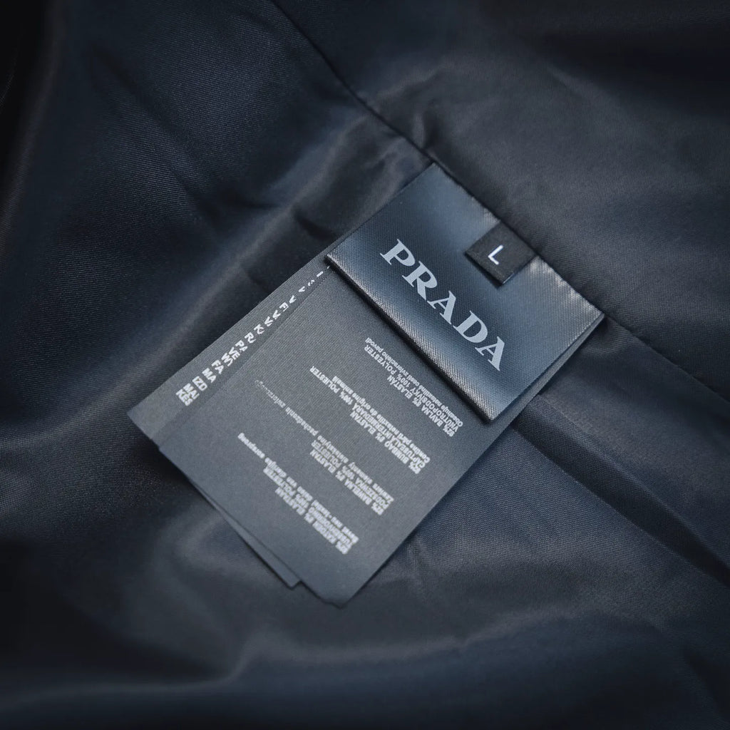 Prada size and care tag on dark fabric lining, marked "L"