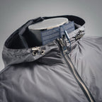 Hood detail of dark gray jacket with front zipper and metal pull ring hardware