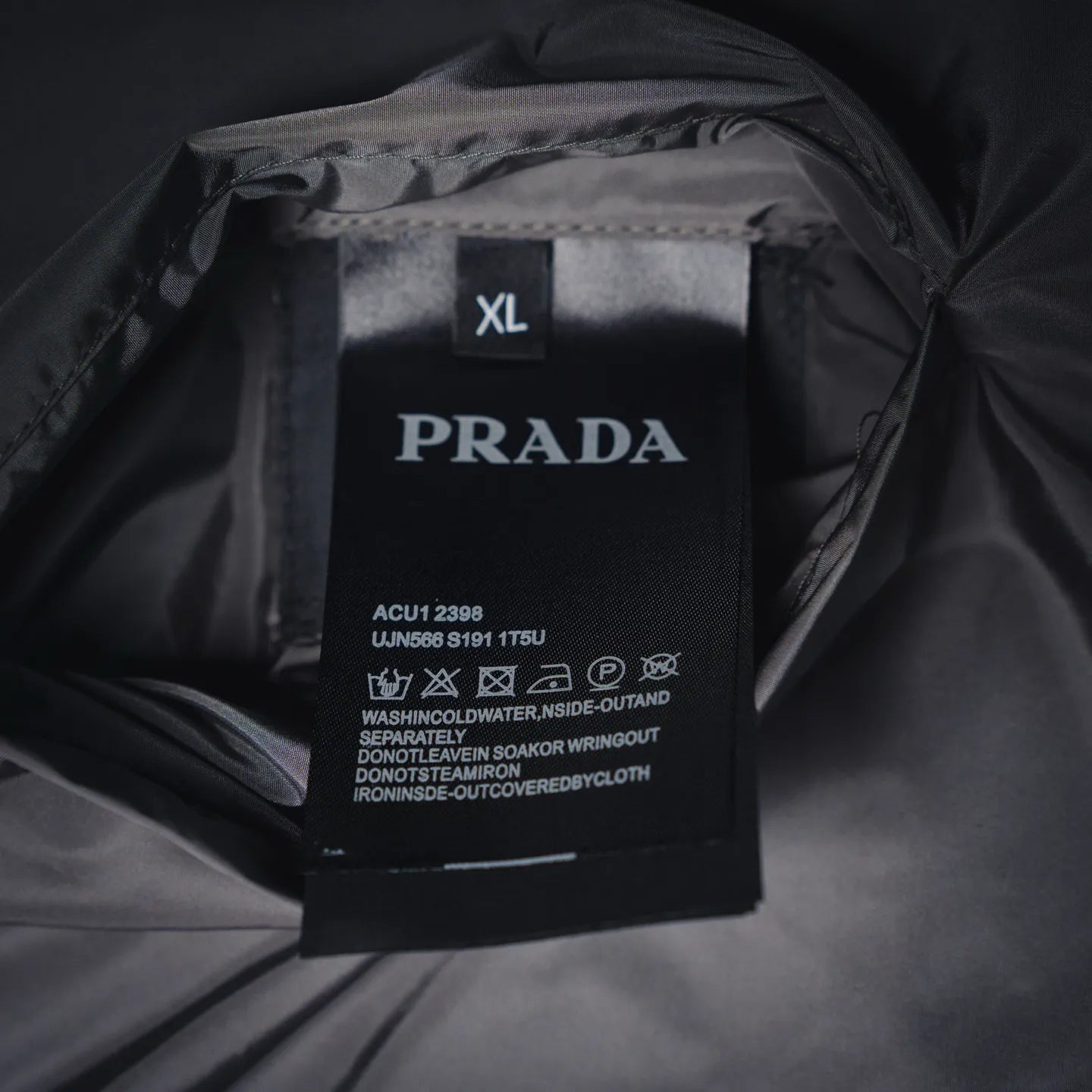 PRADA size XL care label on dark jacket lining, with model and washing instructions