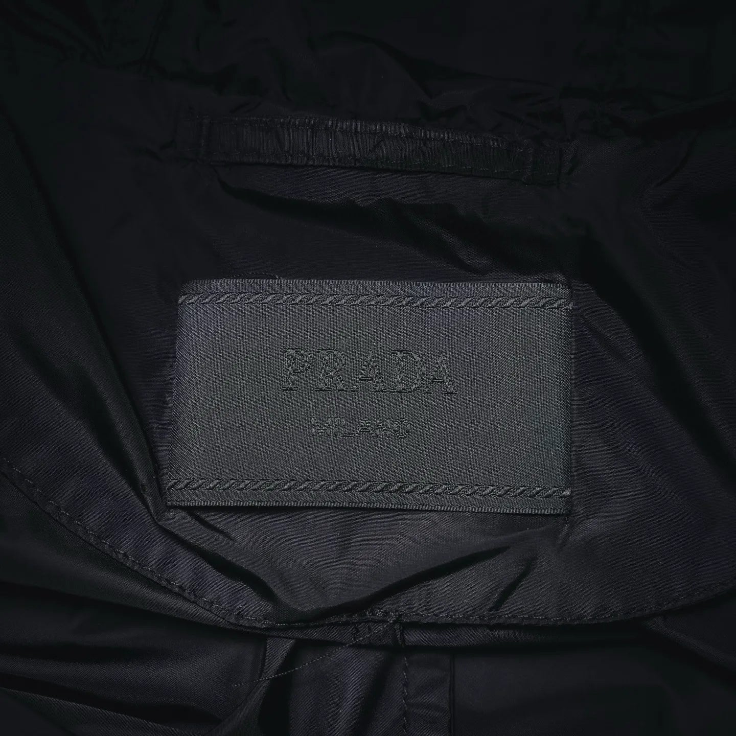 Prada brand size label inside black jacket collar