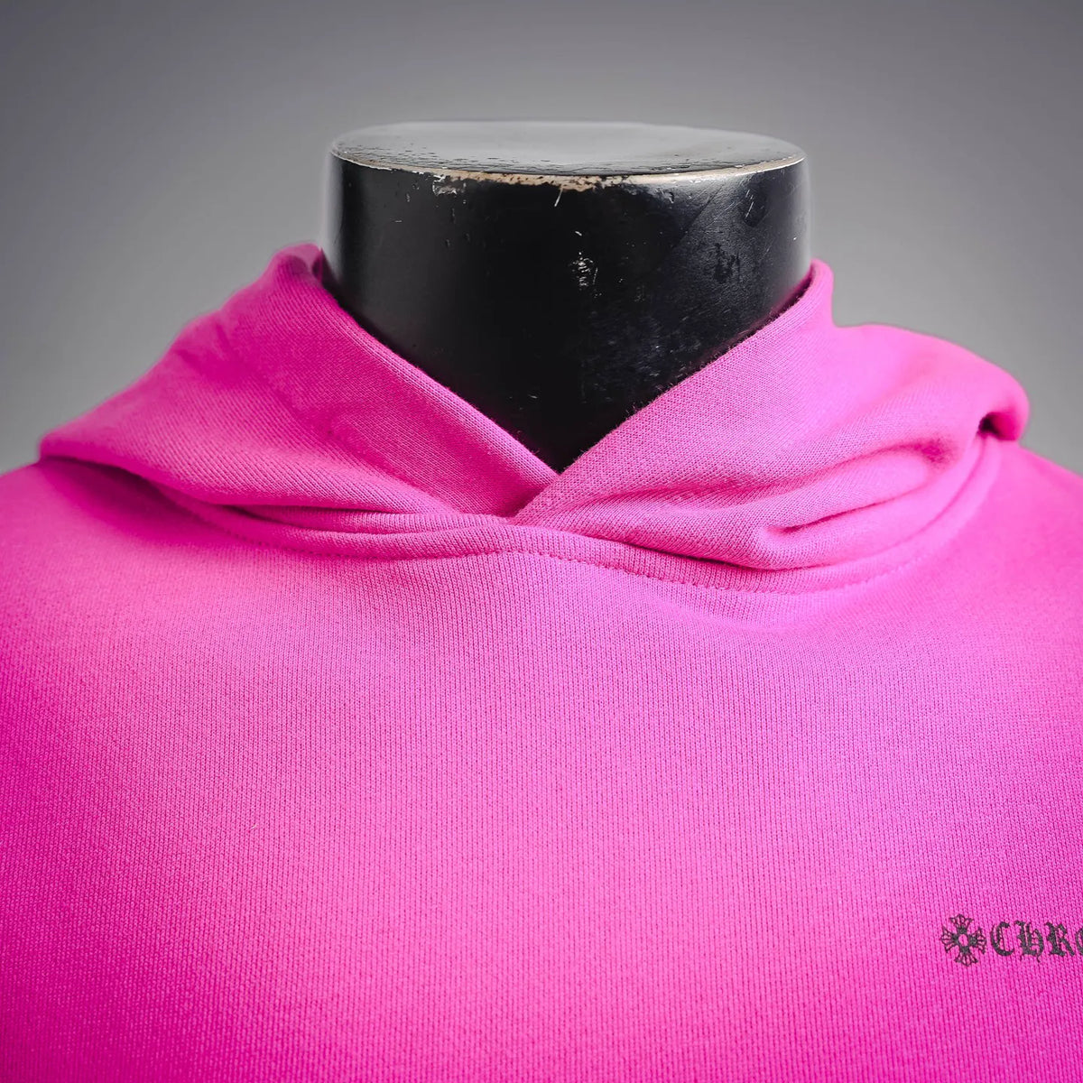 Fuchsia hoodie close-up at collar with small chest logo embroidery