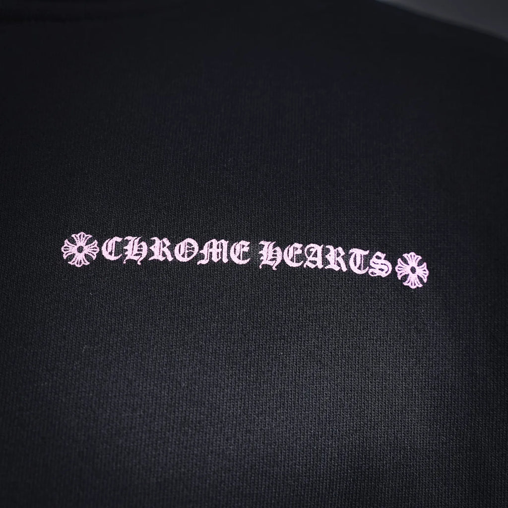 Chrome Hearts logo text close-up on dark hoodie fabric.