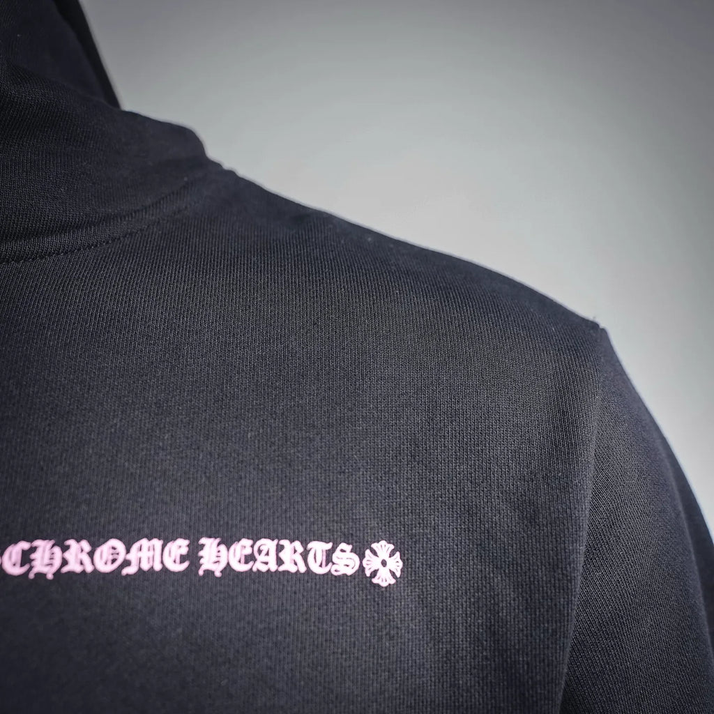 Chrome Hearts hoodie shoulder detail with small pink flower logo print.