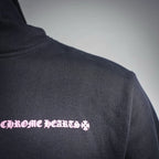 Chrome Hearts hoodie shoulder detail with small pink flower logo print.