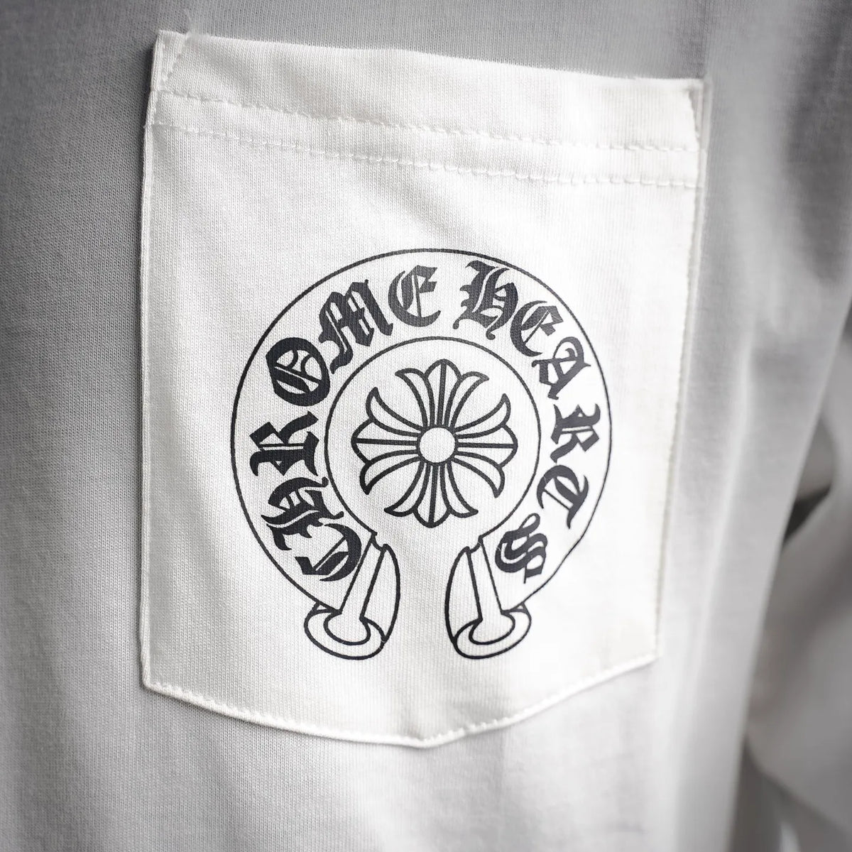White chest pocket on long-sleeve T-shirt with circular logo patch