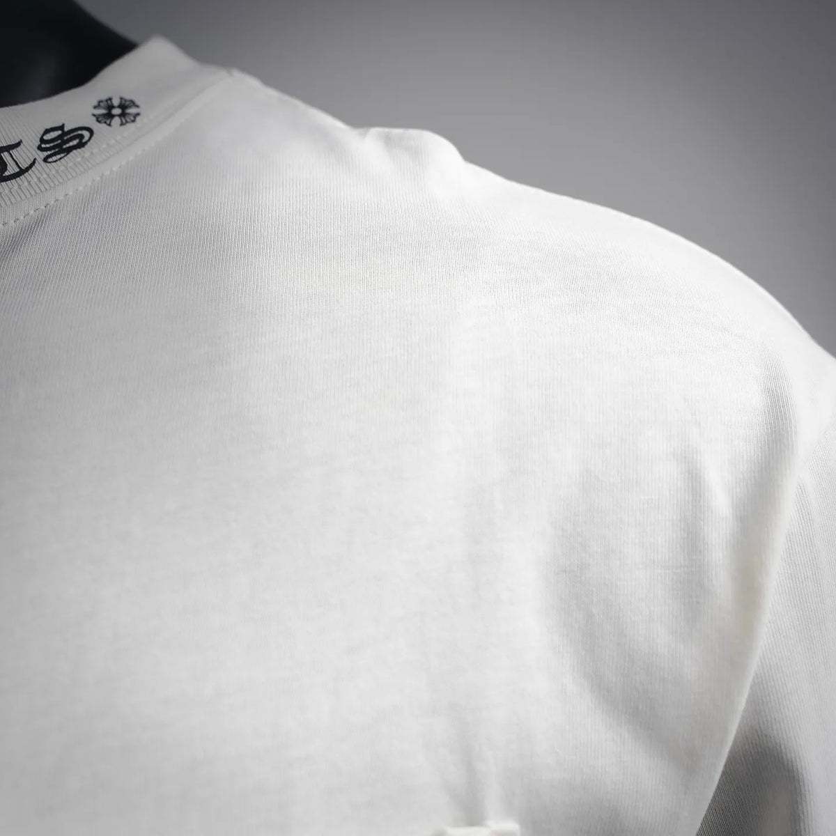 White long-sleeve T-shirt shoulder with visible seam stitching