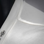 White long-sleeve T-shirt neckline seam with small embroidered detail