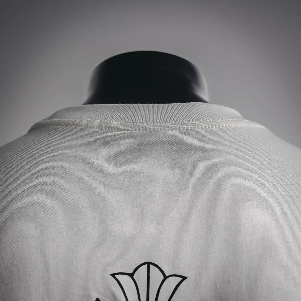 White long-sleeve T-shirt back view with crew neck and small emblem on shoulder