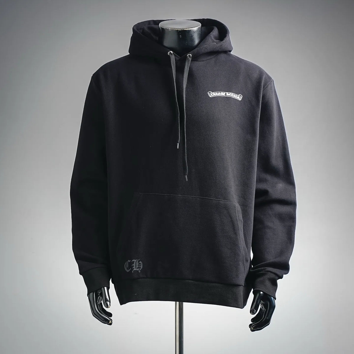 Black long-sleeve pullover hoodie with hood and drawstring, small chest logo.