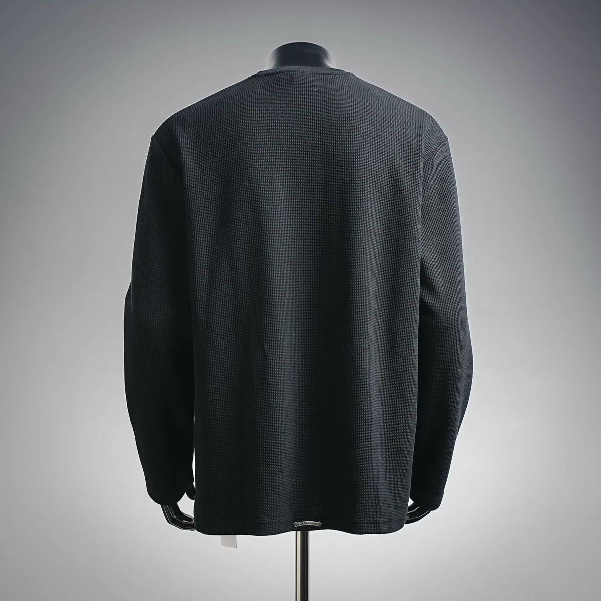 Dark long-sleeve henley shirt shown from back on a mannequin