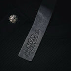 Leather-look hem label with embossed logo text on dark henley