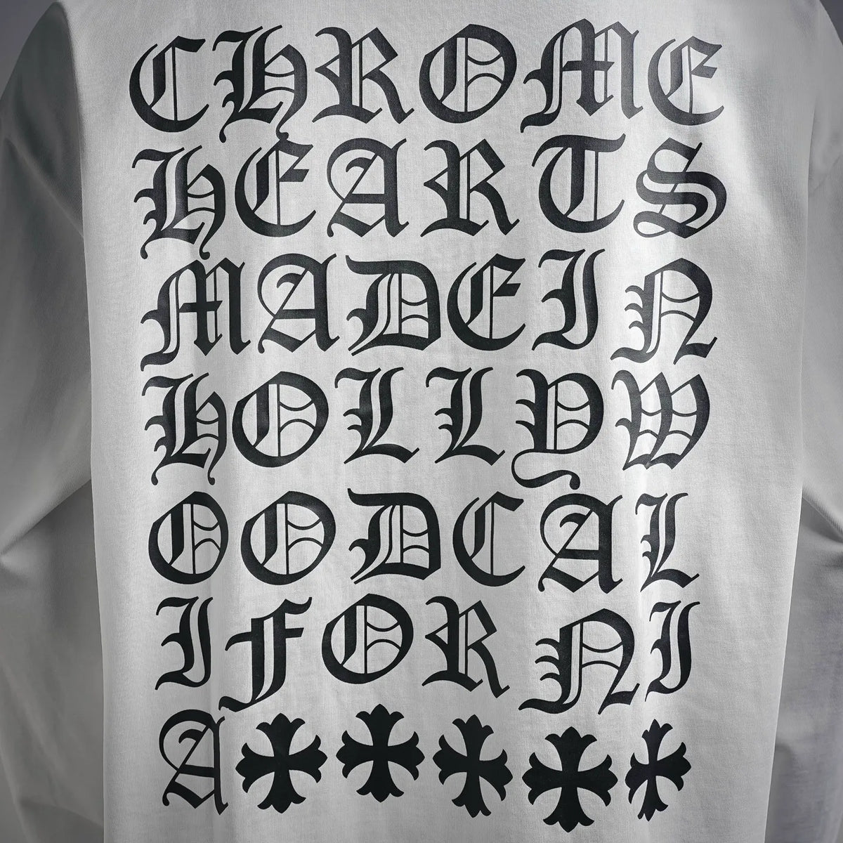 Close-up of black gothic lettering print on white long-sleeve T-shirt