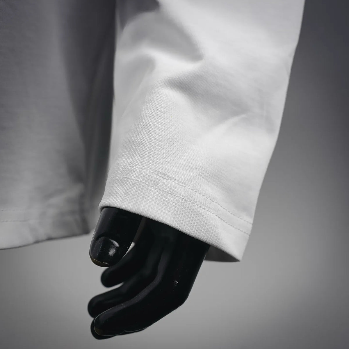 White long-sleeve T-shirt sleeve cuff with stitched hem detail
