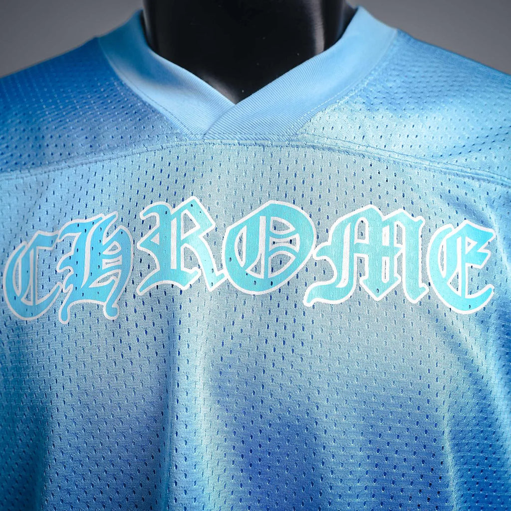 Light blue V-neck jersey close-up with arched front logo text and stitched seam
