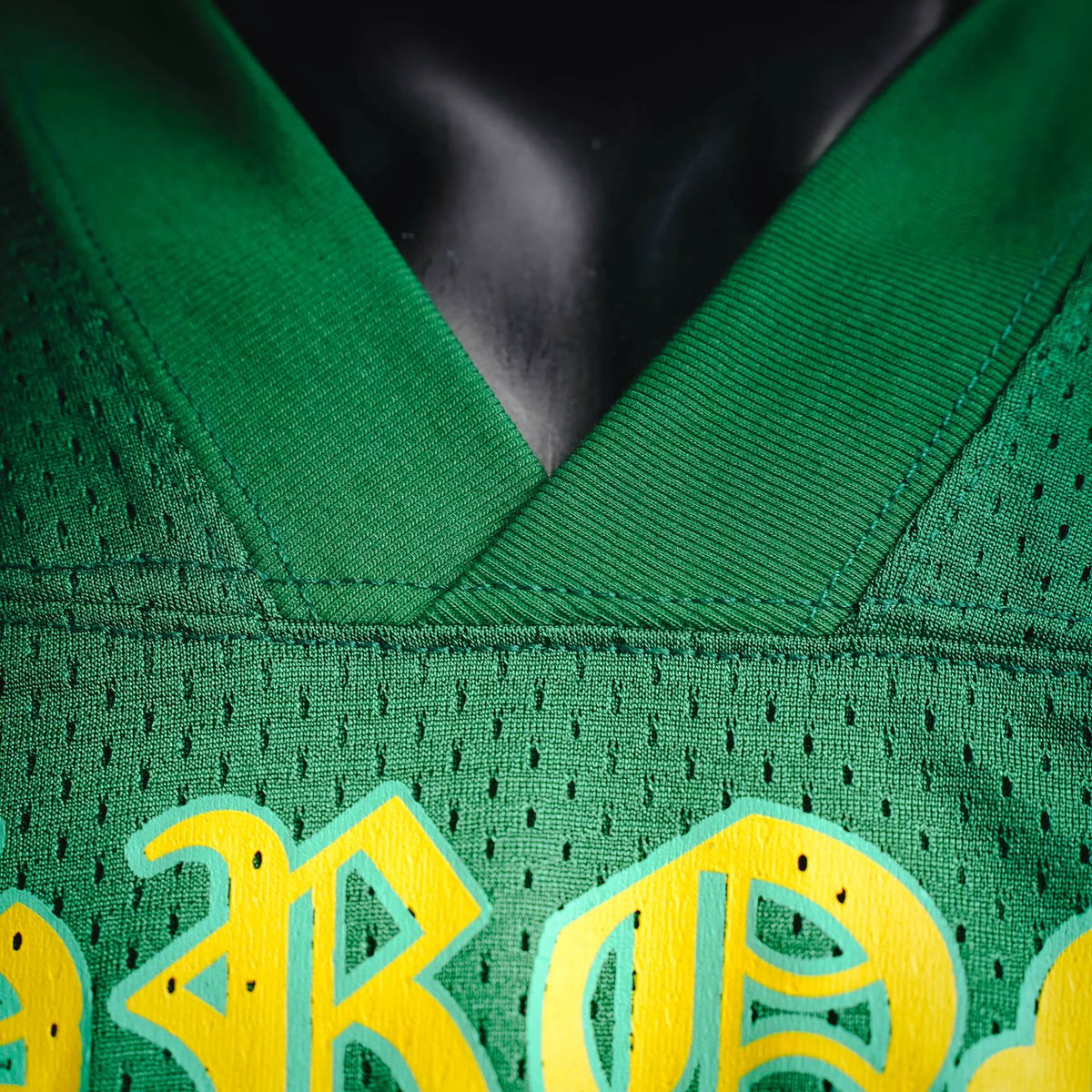 Green jersey collar and textured fabric with partial yellow graphic