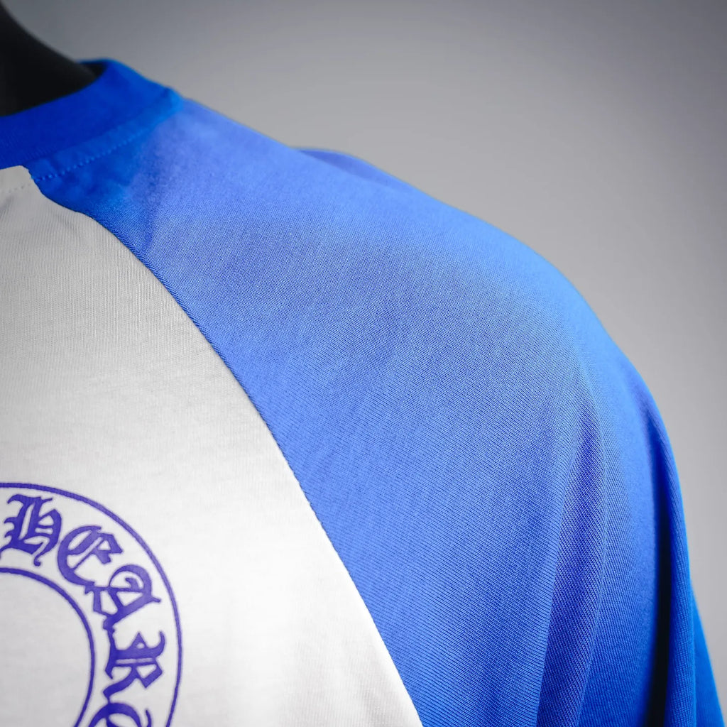 Long-sleeve raglan shirt shoulder close-up, blue sleeve panel over white body