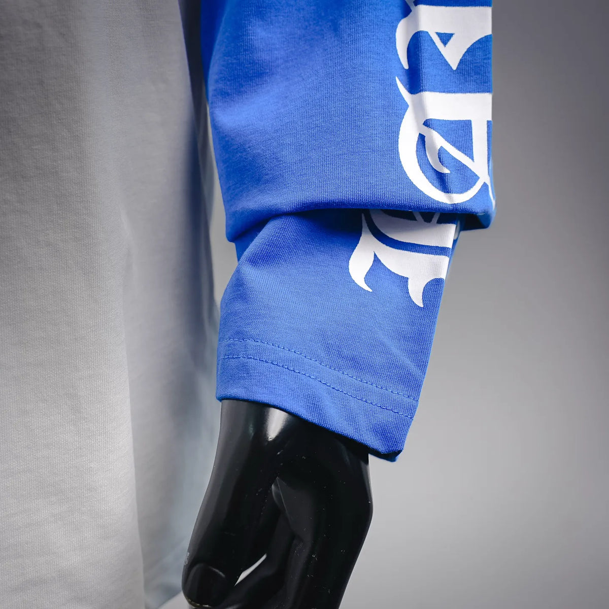 Long-sleeve raglan shirt blue sleeve with printed graphics near the cuff