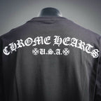 Back of dark long-sleeve T-shirt with large white U.S.A. text and ornamental emblem